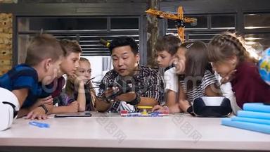 有创造力的孩子与老师一起启动电子构造器与风扇和转动手电筒。 有创意的学生